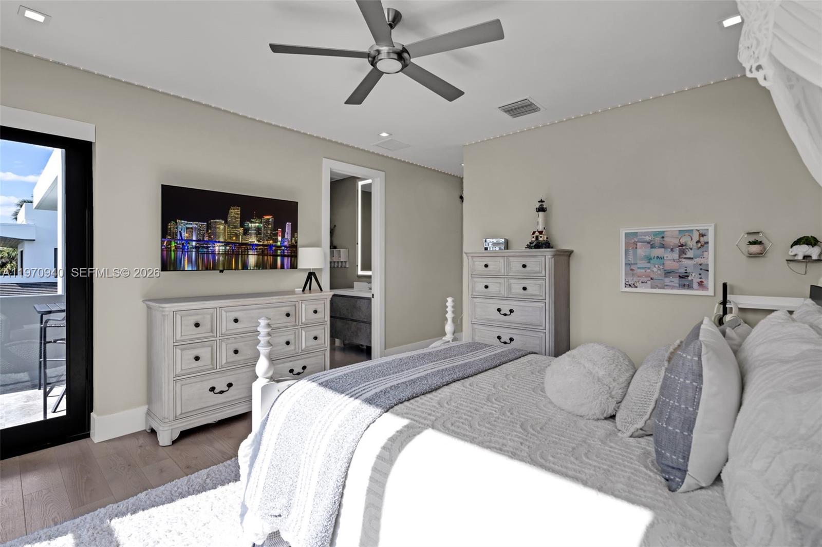 225 Northeast 3rd Street Boca Raton, FL 33432 - Photo 26 of 36 a bedroom with a bed and a mirror on the dresser