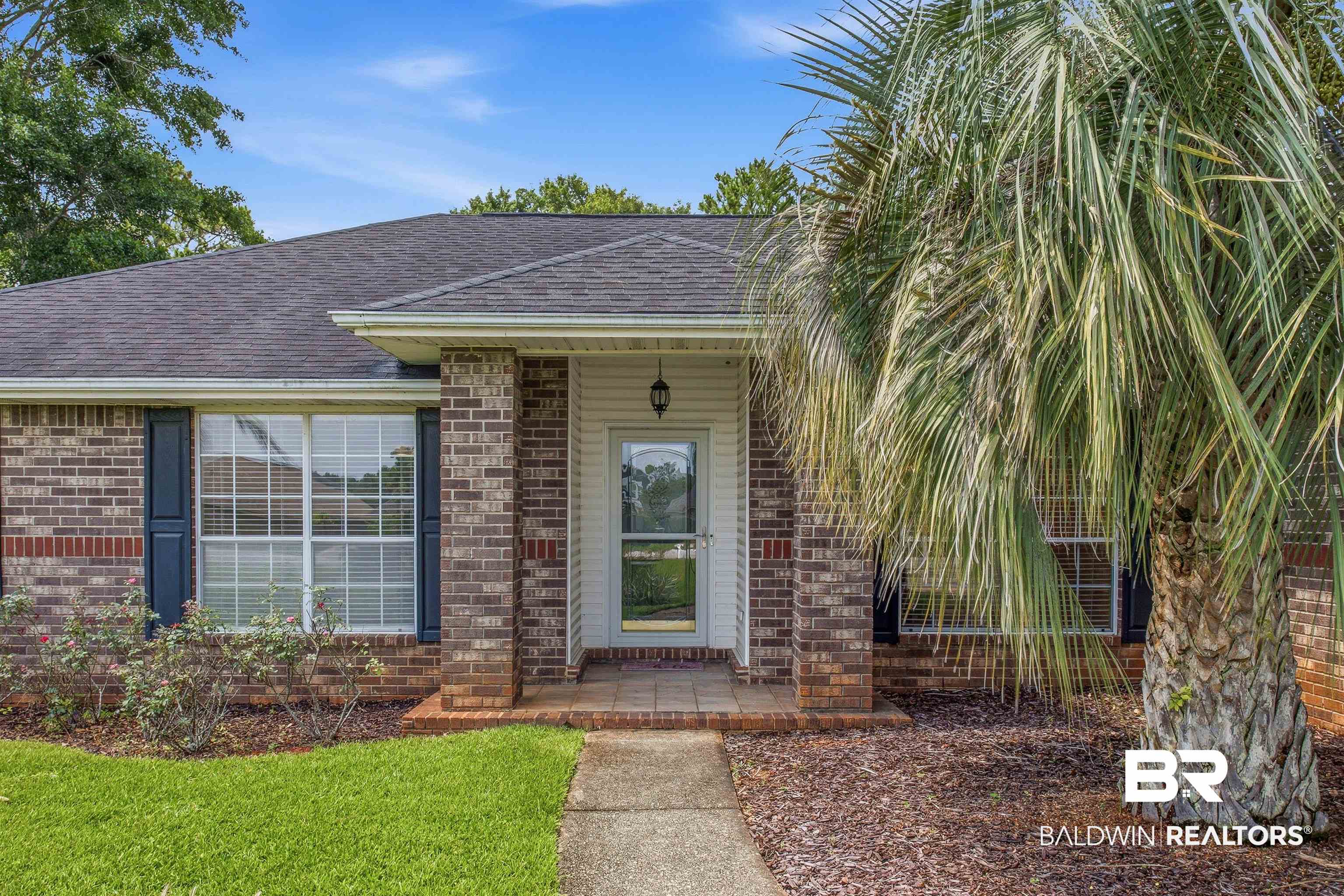 22685 County Road 12 Foley, AL 36535 - Photo 10 of 89 Brick facade residence with a covered entryway and a prominent palm tree