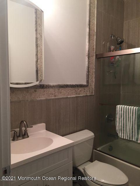 1066 Ocean Avenue, Unit 3 Sea Bright, NJ 07760 - Photo 11 of 12 a bathroom with a sink a toilet and mirror