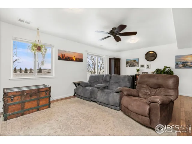 a living room with furniture and a ceiling fan