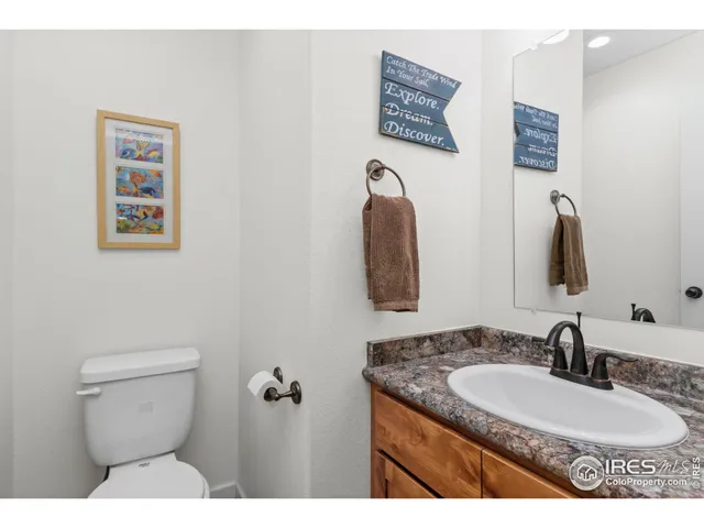 a bathroom with a granite countertop toilet sink and mirror