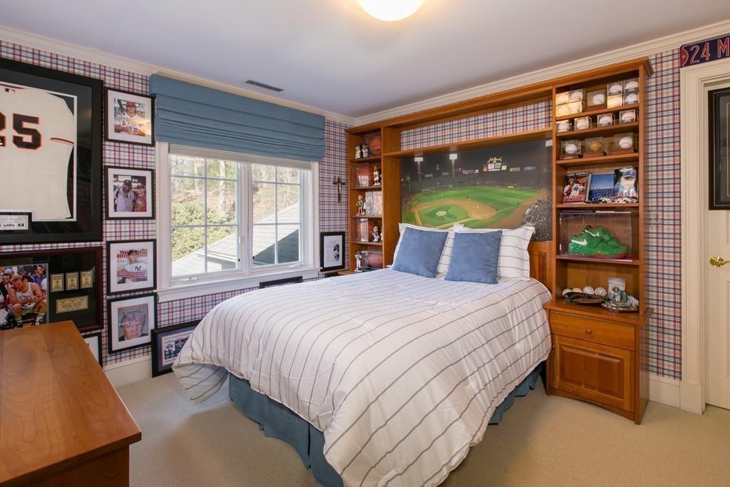 4 Garland Road Lincoln, MA 01773 - Photo 19 of 31 a bedroom with a bed a bookshelf and a large window