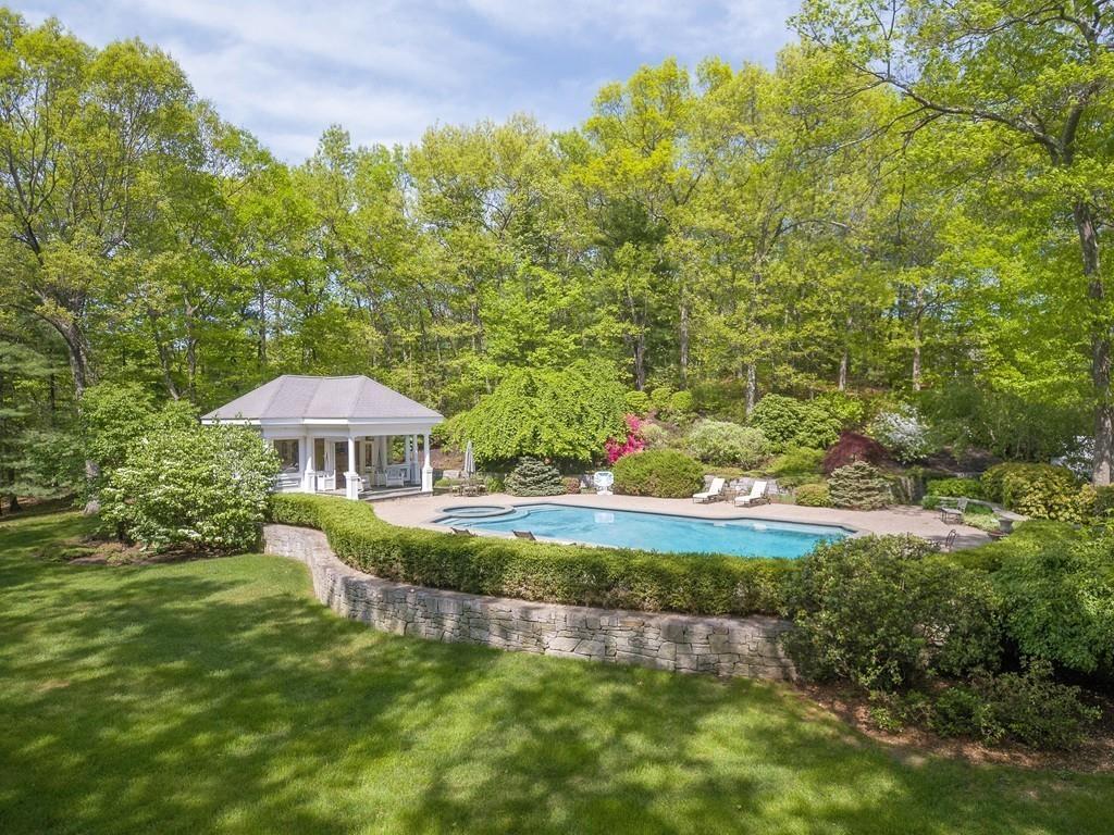 4 Garland Road Lincoln, MA 01773 - Photo 9 of 31 a view of a garden with a bench under an umbrella