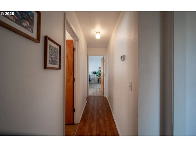 a view of a hallway with wooden floor