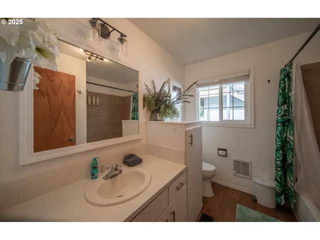 a bathroom with a sink vanity granite tub and a mirror
