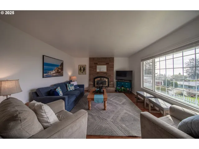 a living room with fireplace furniture and a large window