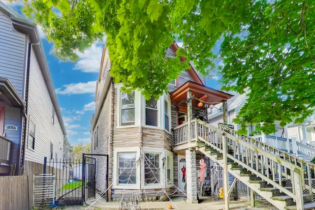 a front view of a house with a tree