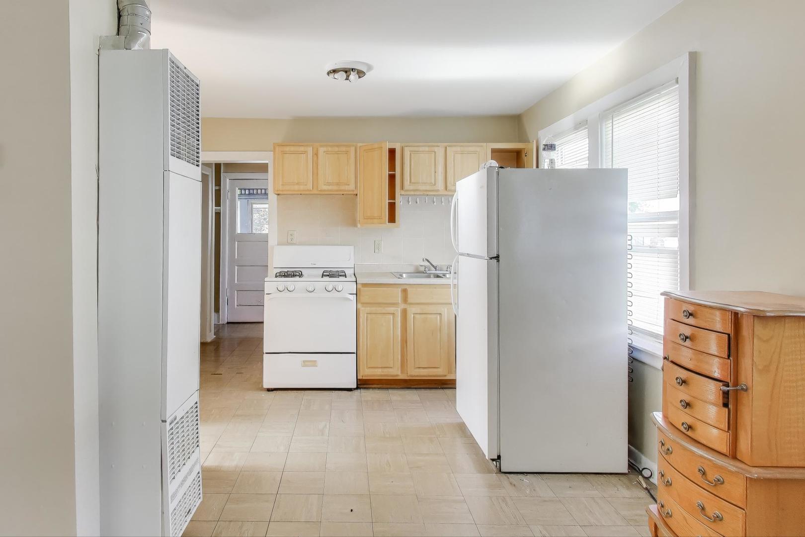 4322 North Monticello Avenue Chicago, IL 60618 - Photo 23 of 37 a kitchen with a refrigerator a stove top oven and cabinets