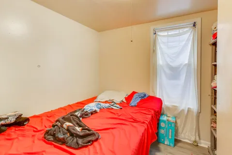 a bed sitting in a bedroom next to a window