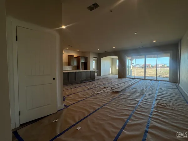 a view of a hallway with wooden floor and a kitchen