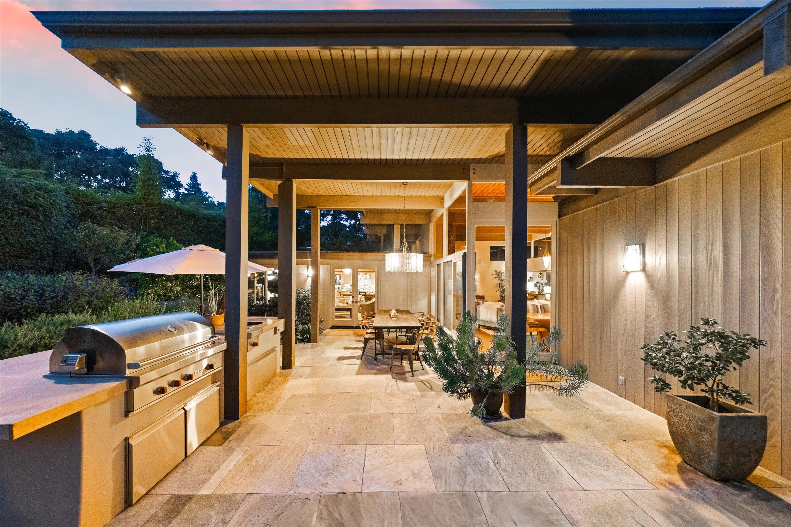 655 Oak Springs Lane Santa Barbara, CA 93108 - Photo 15 of 39 a view of a patio with table and chairs potted plants with wooden floor and fence