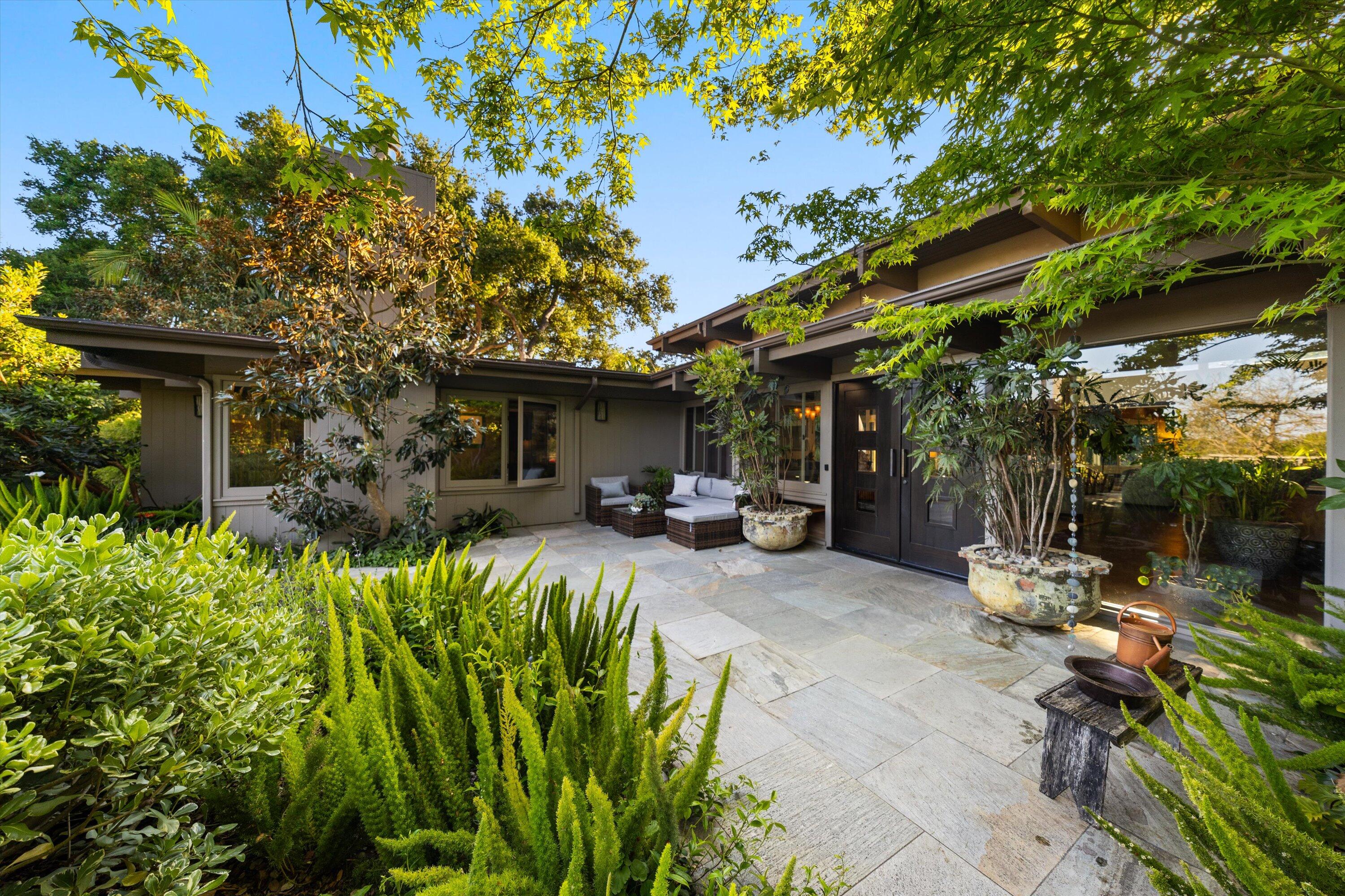 655 Oak Springs Lane Santa Barbara, CA 93108 - Photo 5 of 39 a view of a patio with table and chairs potted plants and large tree