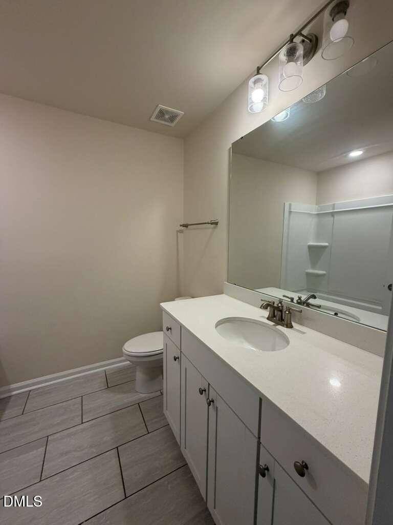 336 Abbots Ml Drive Raleigh, NC 27603 - Photo 15 of 25 a bathroom with a sink a toilet and a mirror