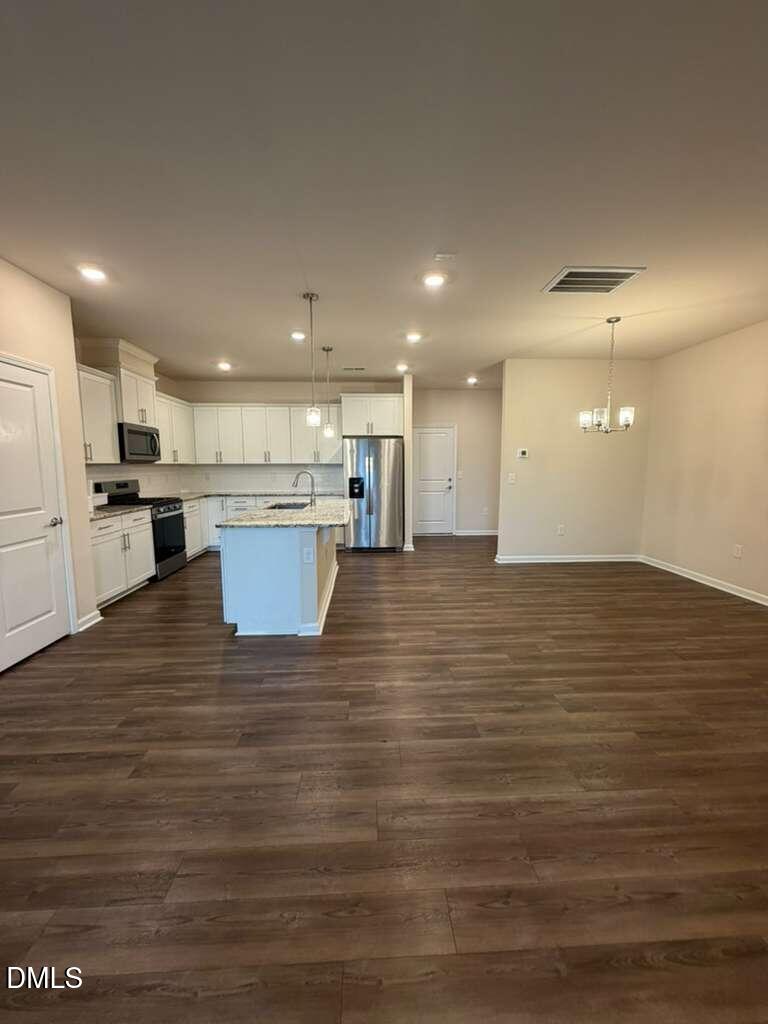 336 Abbots Ml Drive Raleigh, NC 27603 - Photo 3 of 25 a view of kitchen and empty room with wooden floor