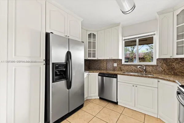 a kitchen with stainless steel appliances granite countertop a refrigerator and a sink