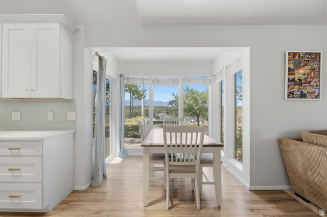 5788 Walden Ridge Drive Murray, UT 84123 - Photo 10 of 29 Dining area with expansive window wall, featuring a sliding glass door and wood-finish flooring