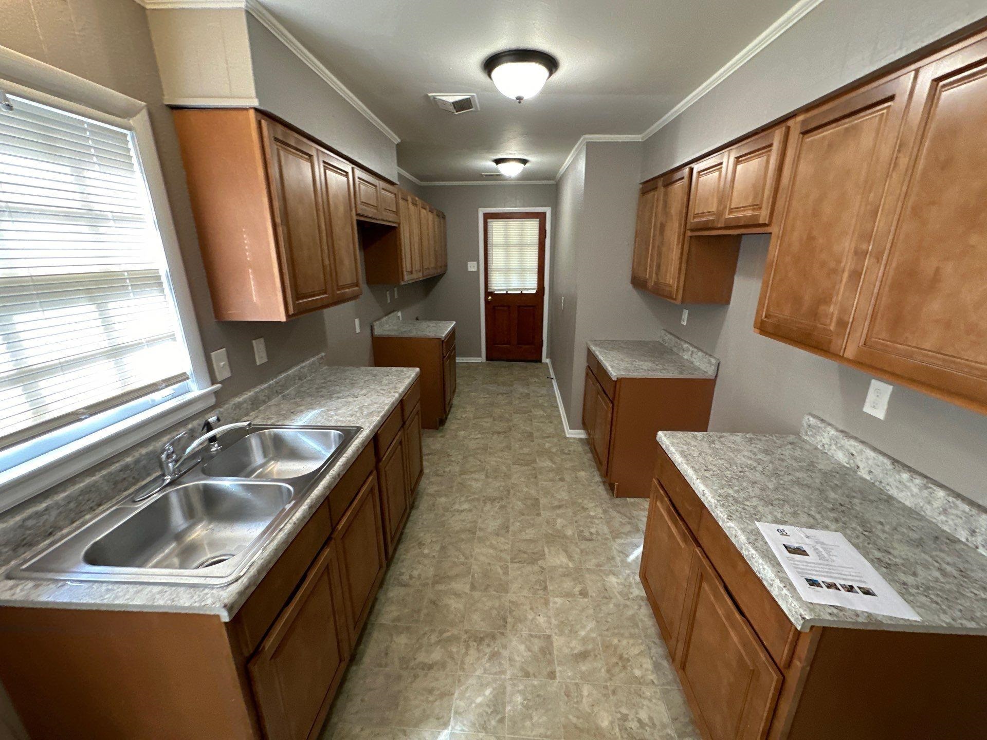 10 West Mitchell Road Memphis, TN 38109 - Photo 9 of 11 Kitchen with a sink, visible vents, and brown cabinets