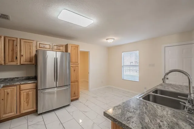 a kitchen with stainless steel appliances granite countertop a stove a sink and a refrigerator