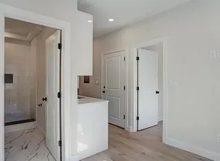 a view of a hallway with closet and wooden floor