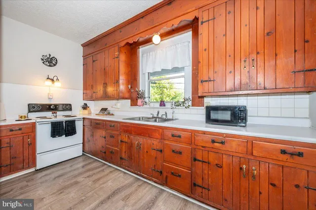 a kitchen with stainless steel appliances granite countertop a stove a sink and white cabinets