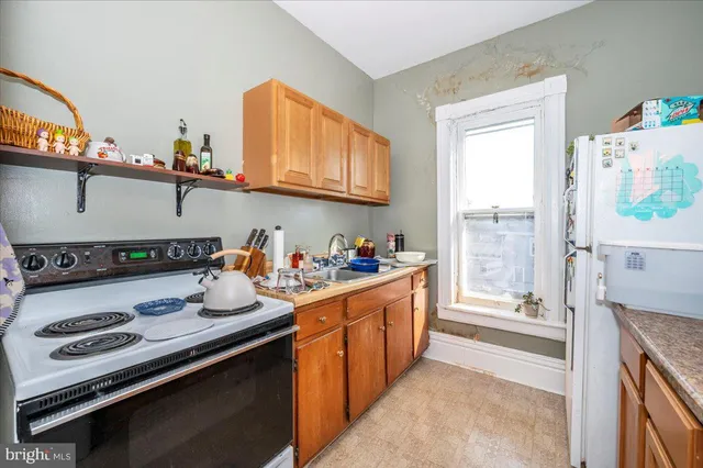 a kitchen with granite countertop a sink stove and refrigerator