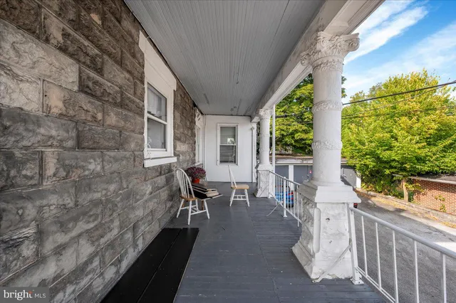 a balcony with wooden floor and outdoor seating