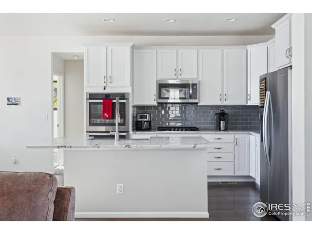 a kitchen with kitchen island a sink stainless steel appliances and cabinets