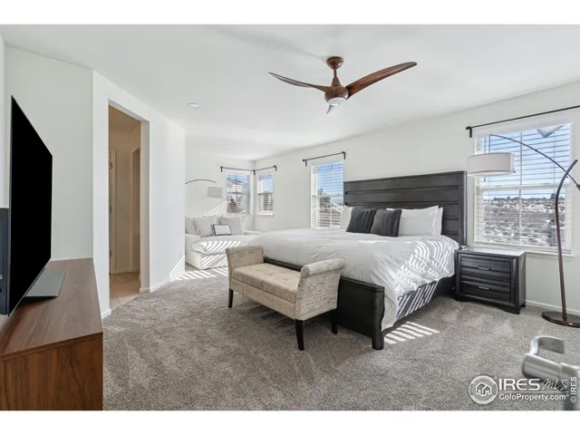 a bedroom with a large bed and a flat tv screen