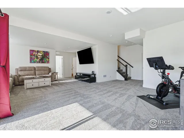 a living room with furniture a flat screen tv and a mirror