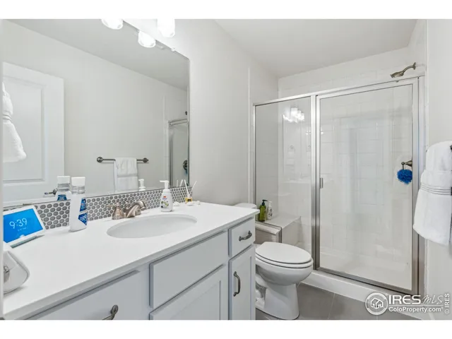 a bathroom with a sink a toilet a mirror and shower