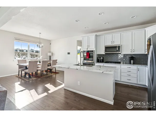 a kitchen with white cabinets and appliances
