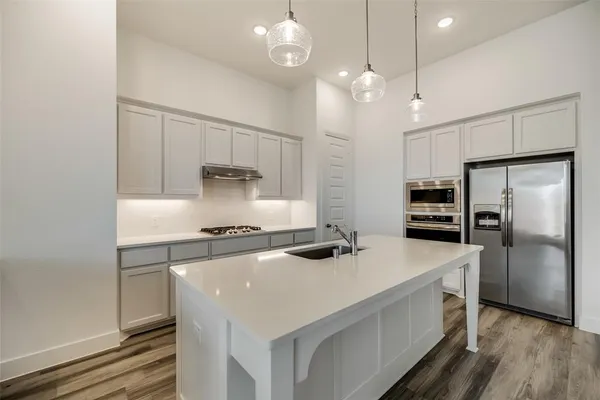 a kitchen with a stove a refrigerator and a sink