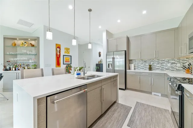 a kitchen with a sink a counter top space stainless steel appliances and cabinets