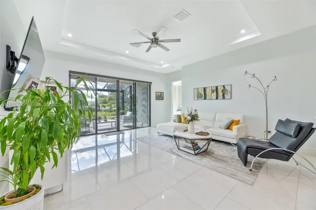 a living room with patio furniture and a potted plant