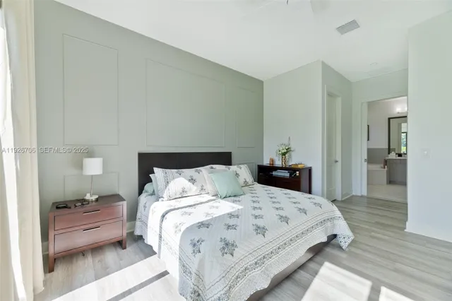 a bedroom with a bed and wooden floor