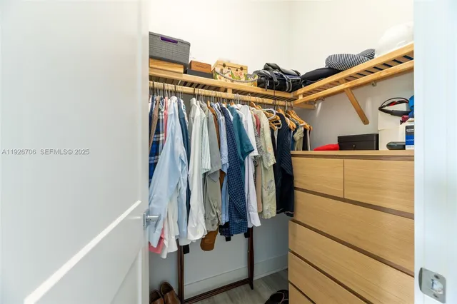 a view of walk in closet with clothes and shoes