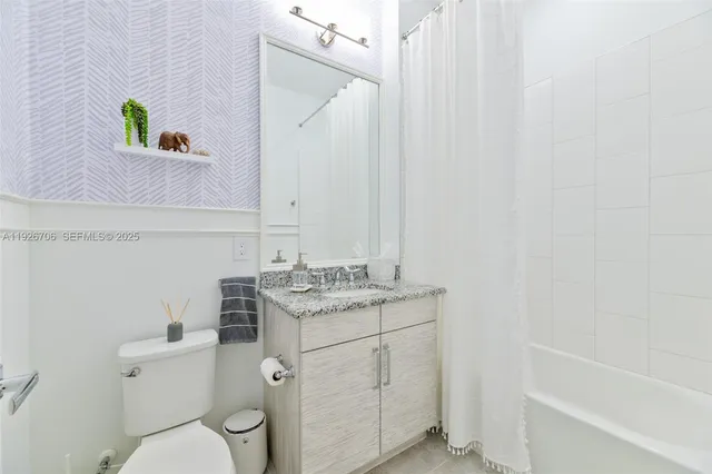 a bathroom with a granite countertop toilet sink and mirror