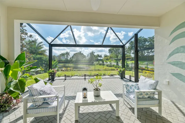 a living room with large windows and a table