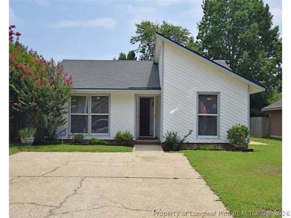 a front view of a house with a garden and plants