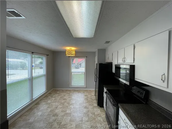 a kitchen with a refrigerator and a stove top oven