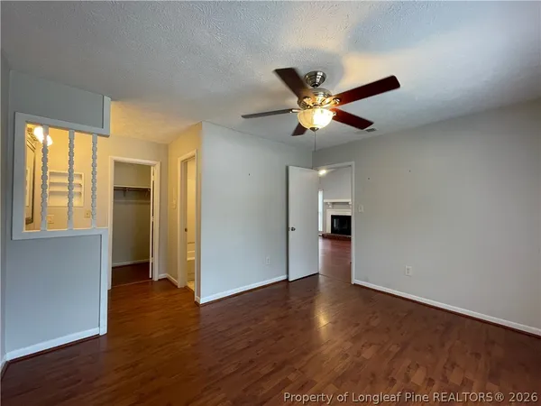 a view of an empty room with window and wooden floor