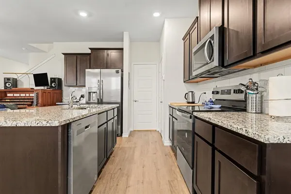 a kitchen with stainless steel appliances granite countertop a sink stove and refrigerator