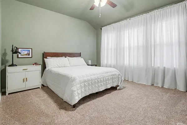 a spacious bedroom with a bed and a chandelier
