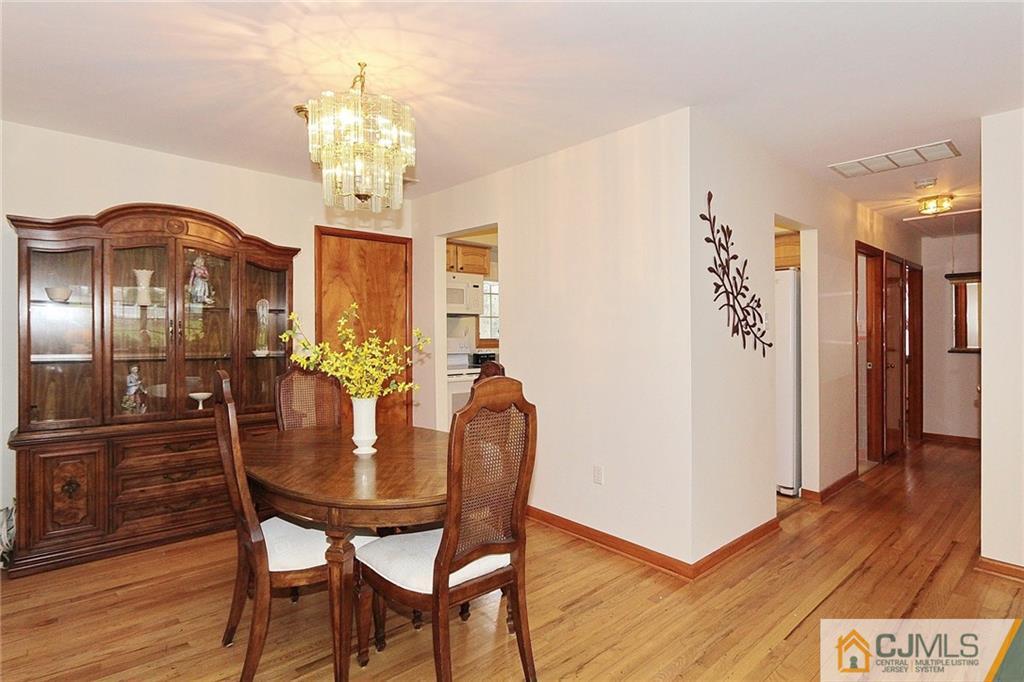 93 Morningside Road Colonia, NJ 07067 - Photo 6 of 23 a dining room with furniture a chandelier and wooden floor