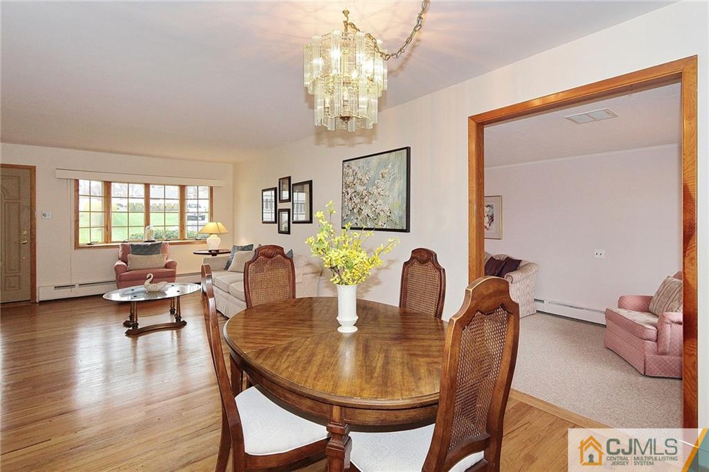 93 Morningside Road Colonia, NJ 07067 - Photo 7 of 23 a dining room with furniture a chandelier and wooden floor
