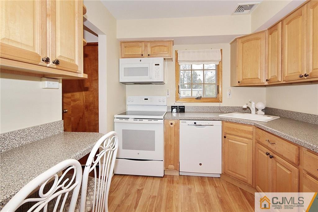 93 Morningside Road Colonia, NJ 07067 - Photo 8 of 23 a kitchen with wooden cabinets and a stove