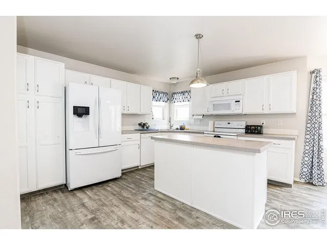 a kitchen with white cabinets and white appliances