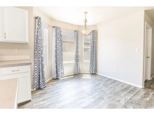 a view of an empty room with closet and entryway