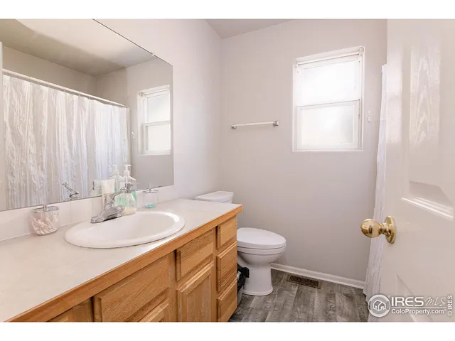 a bathroom with a granite countertop sink toilet and a mirror