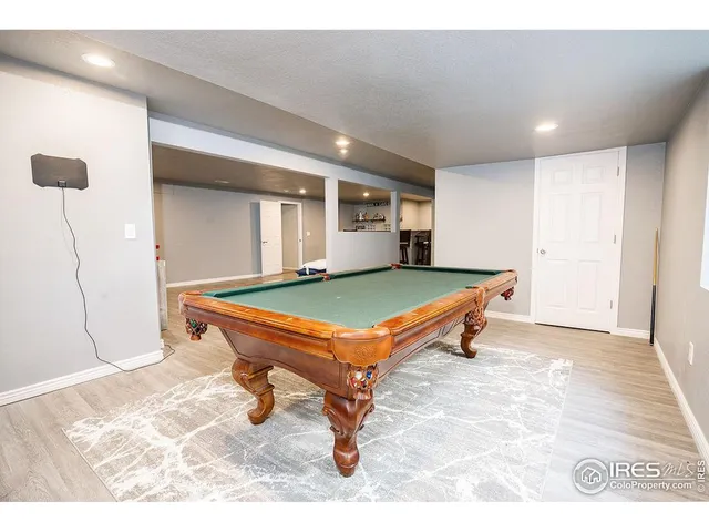 a room with wooden floor and pool table
